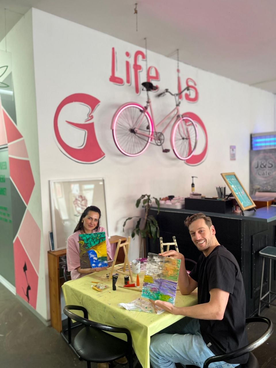Life Is Good Café logo wall with guests painting
